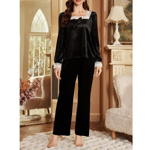 Detail of black velvet pajamas set with white lace trim and bowknot on square neckline