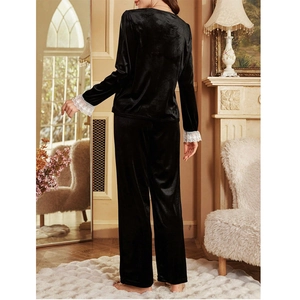 Back view of velvet pajama set with lace cuffs in a cozy European home setting