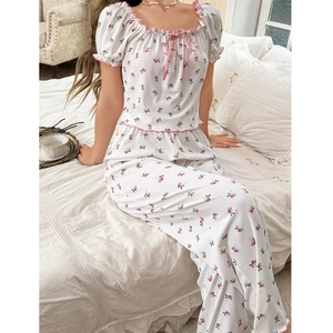 Detailansicht des Damen-Pyjama-Sets mit rosa Rosendruck und Rüschenbesatz am Saum