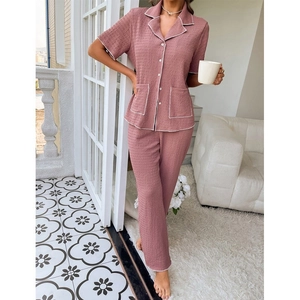 Detailed view of the dusty pink textured fabric and white piping on the pajama set