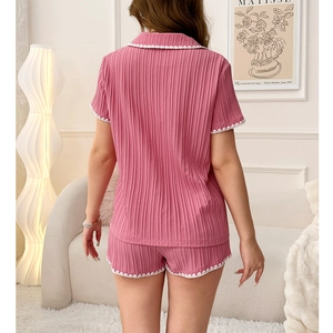 Détail d'un pyjama rose côtelé avec des bordures blanches ondulées au dos du short court