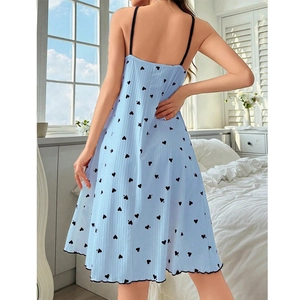Detail of light blue slip dress with black heart prints and lettuce trim on ribbed fabric