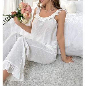 Detail of white two-piece sleepwear set with ruffled edges and dotted swiss fabric texture