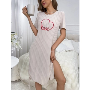 Detail of beige ribbed knit dress featuring a red heart print and side drawstring
