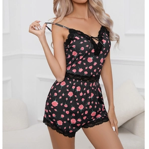 Détail de la dentelle florale sur l'ensemble pyjama noir avec imprimé de roses