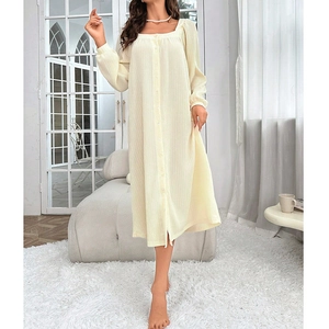 Detail of square neckline and button placket on cream long-sleeve cotton nightdress