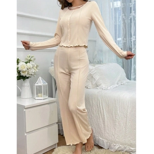 Detail of beige V-neck long sleeve pajamas featuring decorative buttons and ruffled hem