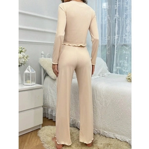 Women's apricot ribbed lounge set featuring long sleeve top and wide leg pants in bedroom