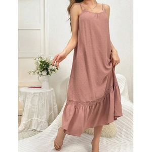 Detail of a pink Swiss dot maxi dress featuring a ruffle hem and elegant spaghetti straps