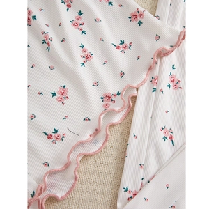 Détail du tricot à fleurs avec bordure rose ondulée et texture côtelée verticale