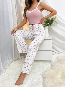 Detailed view of pink ribbed camisole with white lace and floral lounge pants set