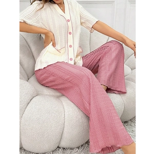 Detail of V-neck white top with pink buttons and textured pink wide-leg lounge pants