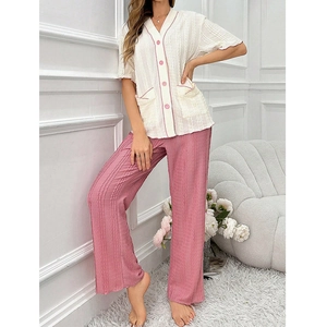 Detail of V-neck button-down pajamas with textured fabric and pink contrast piping
