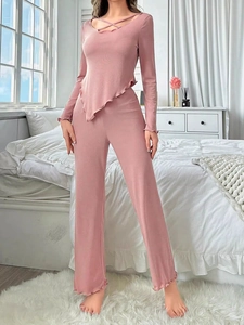 Detail of dusty pink loungewear set with cross-tie V-neck and ruffled edges in ribbed fabric