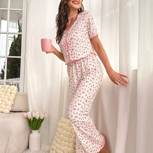 Détail de l'ensemble pyjama à fleurs avec passepoil rose et boutons élégants
