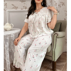 Detail of white pajamas with pink tulip print and lace embroidery on the round neckline