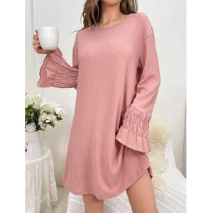 Détail de la chemise de nuit rose à manches longues avec poignets plissés et tissu texturé