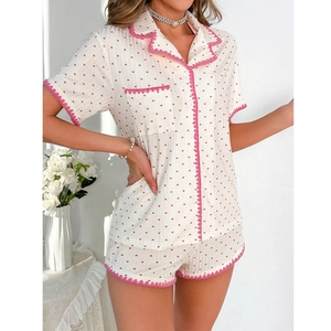 Détails du motif cœur rose et bordure en dentelle sur l'ensemble de pyjama blanc