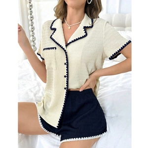 Close-up of seersucker pajama fabric with navy wavy trim and textured details