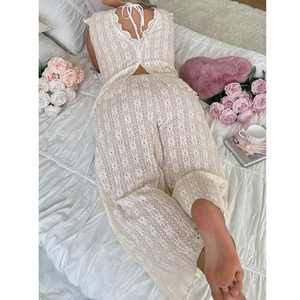 Detail of off-white eyelet lace two-piece set with intricate floral embroidery textures