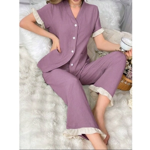 Détail du pyjama lilas montrant les bords à volants et les boutons de l'ensemble confort