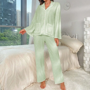 Detail of light green pajama set with vertical pleat texture and white piping trim