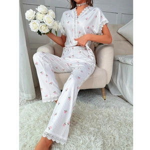 Detail of V-neck pajama top with delicate white lace trim and floral prints