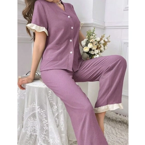 Détail du haut de pyjama lilas avec poignets à volants crème et boutons en nacre