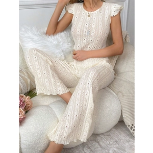 Detail of white two-piece set featuring intricate eyelet lace and sleeveless design
