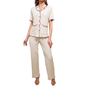 Women's pajama set featuring short sleeve shirt and pants with red scalloped trim details