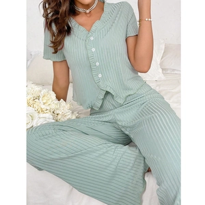Detail of light green V-neck short sleeve top with ruffle edges and button closure
