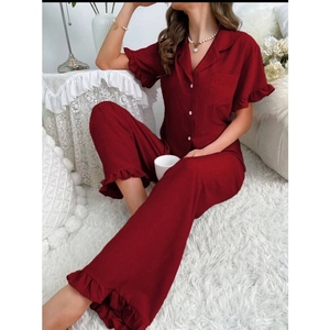 Détail de l'ensemble pyjama rouge avec col à revers, boutons et bords à volants