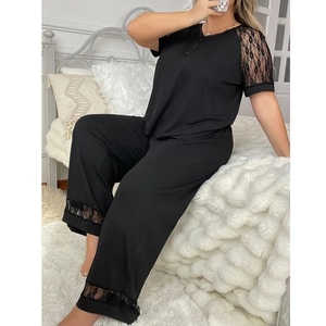 Detail of black lace trim on V-neck loungewear and pants sleeve edges in soft knit fabric
