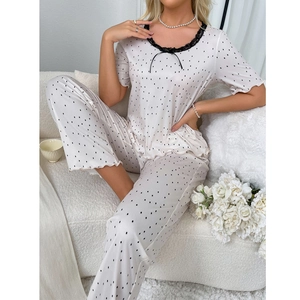 Detailed view of women's polka dot pajama set with lace neckline and bow detail