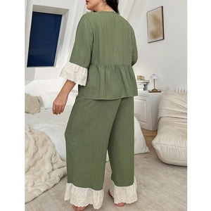 Detail of sage green pajama set with white lace trim on sleeves and ruffled hemline