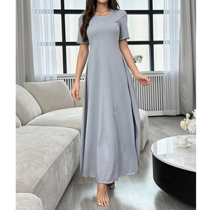 Robe longue grise élégante à manches courtes avec col rond et ourlet en A dans un salon
