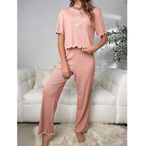 Pink rib-knit pajama set for women with white bows and ruffles on short sleeves and pants