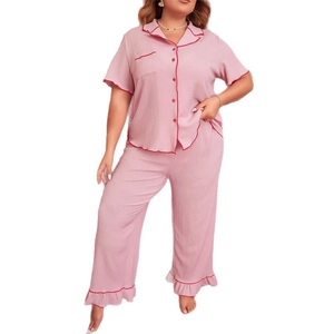 Women's plus size pink pajama set with short sleeves, lapels, and red piping details