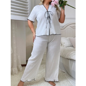 Women's plus size white pajama set with V-neck tie-up top and ruffle hem wide leg pants