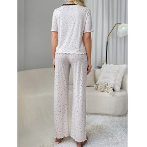 Short sleeve two-piece women's pajama set with black polka dots and ruffle hem detail