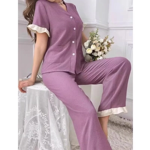 Detail of light purple pajama set with white ruffle trim on sleeves and V-neckline button top