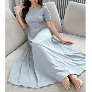 Détail d'une robe de chambre grise à manches courtes et jupe fluide sur un canapé