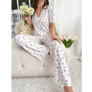 Détail d'un ensemble de pyjama à fleurs avec dentelle, col en V et boutons blancs