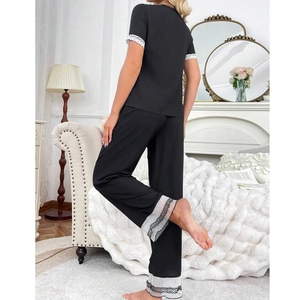 Women's black two-piece pajama set with white lace trim and short sleeves, back view style