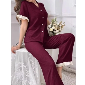 Detail view of burgundy V-neck pajama set with white lace trim and ruffle cuffs