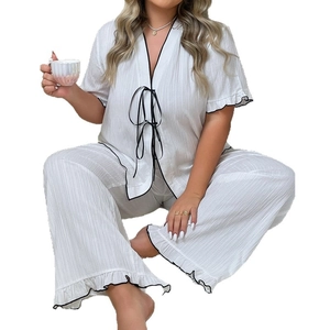 Women's white two-piece pajama set with V-neck, black lace-up ties and ruffled edges