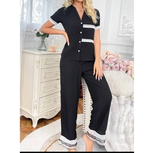 Detail of delicate white lace trim and ruffle edge on black short sleeve pajama top
