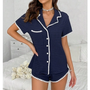 Detailed view of navy blue waffle texture pajama set with white scalloped trim and buttons