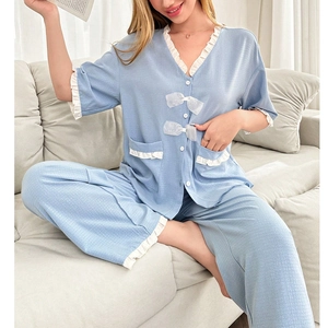 Two-piece light blue pajama set for women with white ruffle trim and sweet bow details
