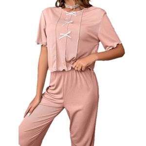 Women's pink ribbed knit two-piece pajama set with white bows and ruffle trim